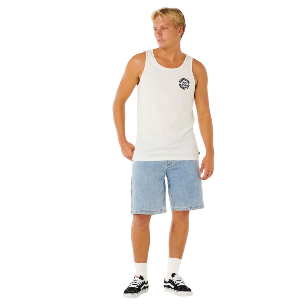 Camiseta tirantes surf Rip Curl Pacific Rinse Tank bone con estampado navy en pecho, combinada con short vaquero y zapatillas, look casual surf.
