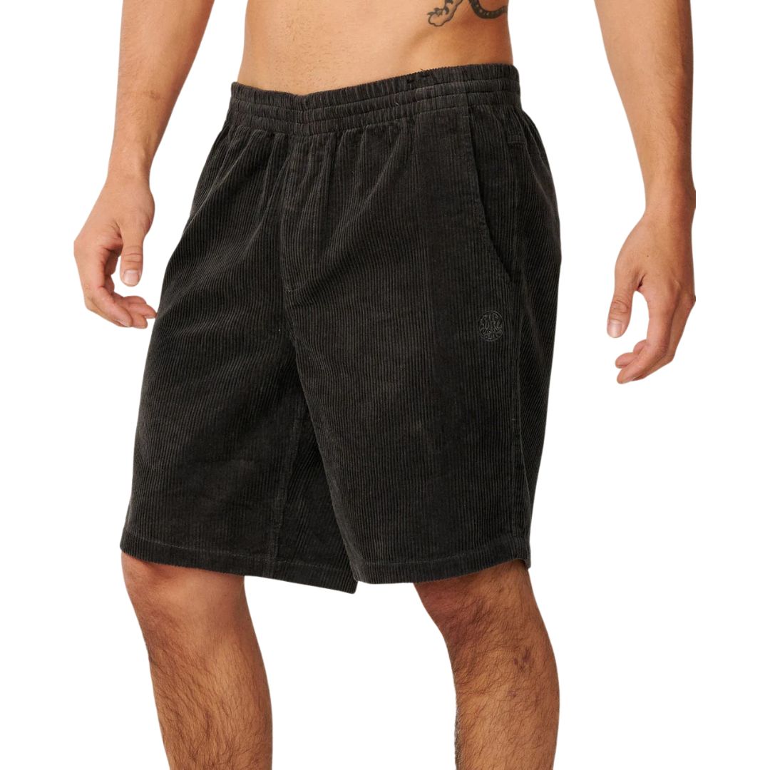 Pantalón corto pana Rip Curl Premium Surf Cord negro, vista lateral con cintura elástica, bolsillo lateral y logo bordado en tejido acanalado acid wash.