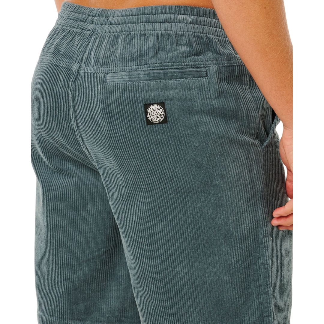 Detalle trasero pantalón corto pana Rip Curl Premium Surf Cord verde pino, etiqueta tejida Rip Curl negra en bolsillo y textura acanalada acid wash.