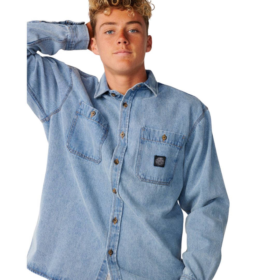 Primer plano de la camisa vaquera Rip Curl Premium Surf Denim L/S en Washed Blue, con detalle del cuello camisero, el bolsillo con parche Rip Curl y el algodón denim lavado.
