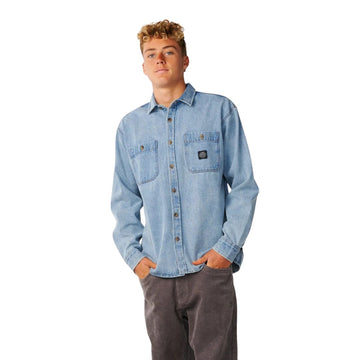 Vista frontal de la camisa vaquera Rip Curl Premium Surf Denim L/S en Washed Blue, con dos bolsillos de parche en el pecho, parche tejido Rip Curl y cierre de botones completo.