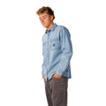 Vista de perfil de la camisa vaquera Rip Curl Premium Surf Denim L/S en Washed Blue, mostrando el cuello camisero, los bolsillos de parche y la caída holgada de la prenda.