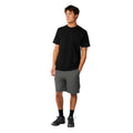Rip Curl S-Series VaporCool Embroid Tee en negro, vista frontal completa con corte relajado, combinada con bermudas grises, mostrando la caída general de la prenda.