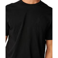 Camiseta Rip Curl S-Series VaporCool Embroid Tee negra, primer plano del logo bordado tono sobre tono en el pecho izquierdo, con el texto Rip Curl bordado debajo.