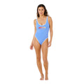 Mujer con bañador entero retro Rip Curl Surf Puff 1 Piece azul cielo, vista frontal completa con logo estampado y pierna de corte alto favorecedor.