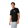 Rip Curl Surf Trip Tee en Black, vista lateral de tres cuartos, mostrando el logo estampado en rosa y verde en el pecho.