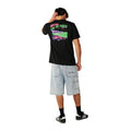 Rip Curl Surf Trip Tee en Black combinada con bermuda vaquera clara, vista trasera de cuerpo entero mostrando el estampado completo.