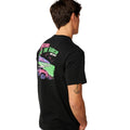 Detalle de la ilustración en la espalda de la Rip Curl Surf Trip Tee en Black, con el todoterreno rosa y la ola verde estampados.