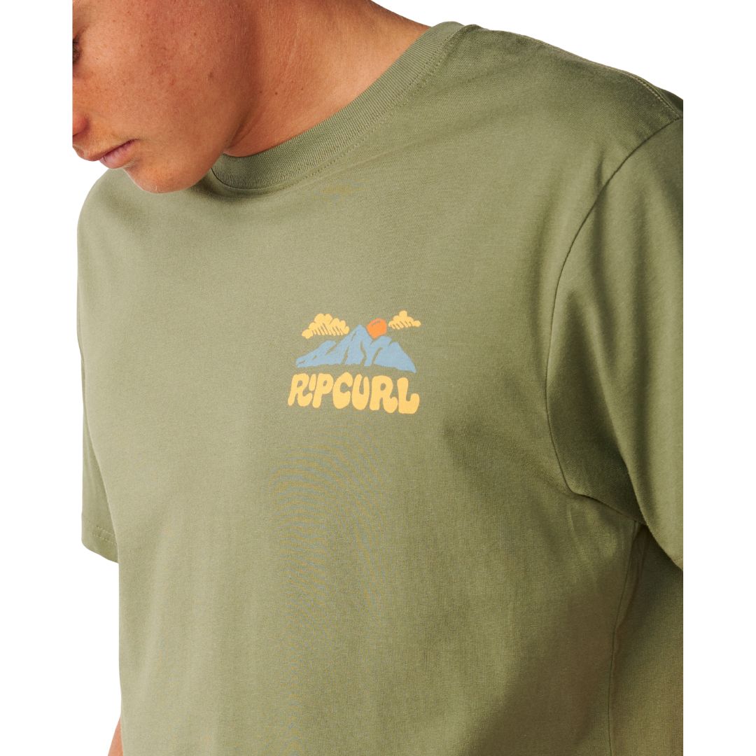 Detalle del logo de montaña, sol y nubes con el texto Rip Curl estampado en el pecho de la Surf Trip Tee en Surplus Green.