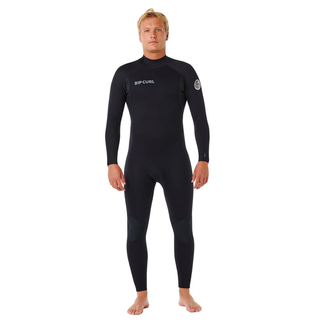 Traje de neopreno RIP CURL TRAD BZ 4/3 en negro, vista frontal completa con logotipo RIPCURL en el pecho y parche circular en la manga, corte integral para surf en aguas frías.
