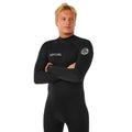 Traje de surf RIP CURL TRAD BZ 4/3 en negro, plano medio con brazos cruzados mostrando el parche circular RIP CURL WETSUITS en la manga y el logotipo TRAD en el puño.