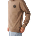 Detalle del logotipo circular negro de la sudadera Rip Curl Wetsuit Icon Crew Walnut para hombre sobre el pecho.