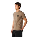 Camiseta Rip Curl Wettie Icon Walnut para hombre con logotipo circular negro en el pecho, vista lateral sobre modelo.