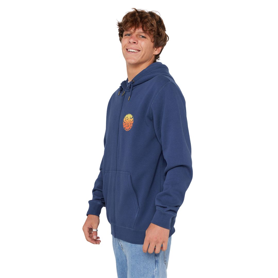 Vista lateral de la sudadera Rip Curl Wettie Passage Icon Zip Thru azul marino claro, con capucha, bolsillos delanteros y cremallera central.