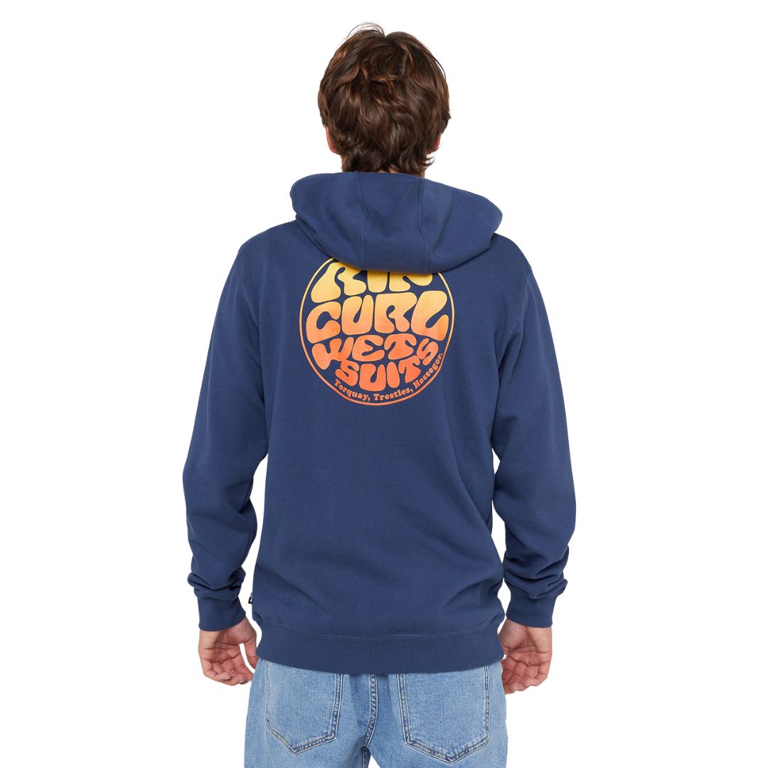 Modelo de espaldas vistiendo la sudadera Rip Curl Wettie Passage Icon Zip Thru azul marino claro, mostrando el gran logotipo circular en la espalda.