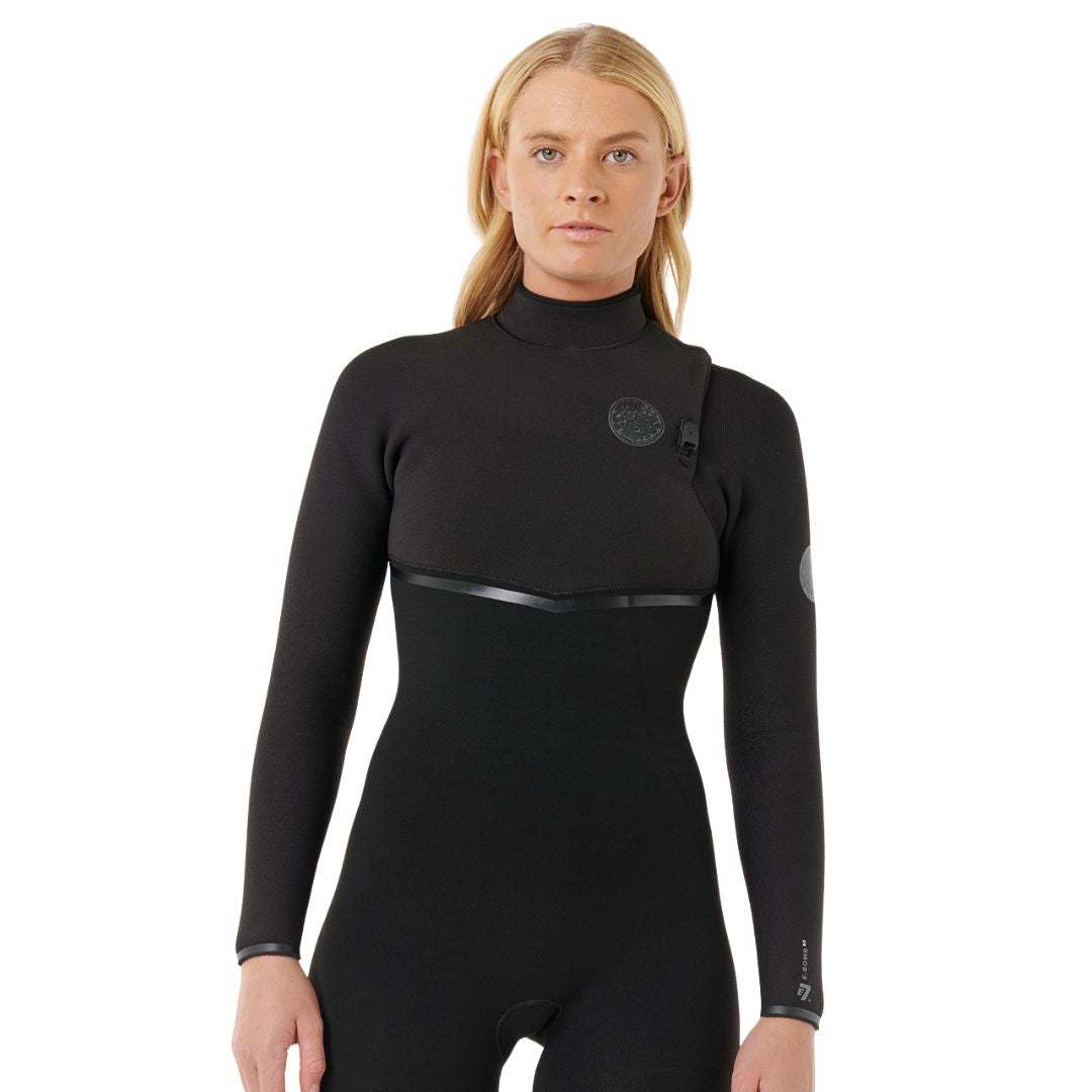 Traje de neopreno Rip Curl E-Bomb Zip Free 4/3 negro, vista lateral con los brazos cruzados, mostrando el logo Rip Curl y el detalle de estrella en la manga.