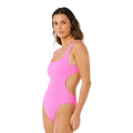 Bañador entero Rip Curl x Surf City 1PC rosa super pink, vista lateral con cut-out lateral, tejido acanalado elástico y escote redondeado.
