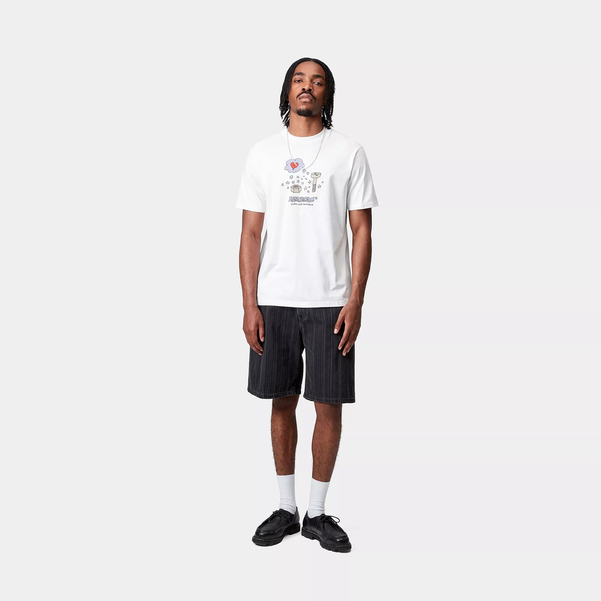 Camiseta blanca Carhartt WIP S/S Work Life Romance T-Shirt con ajuste regular y estampado gráfico, combinada con bermuda y calzado urbano