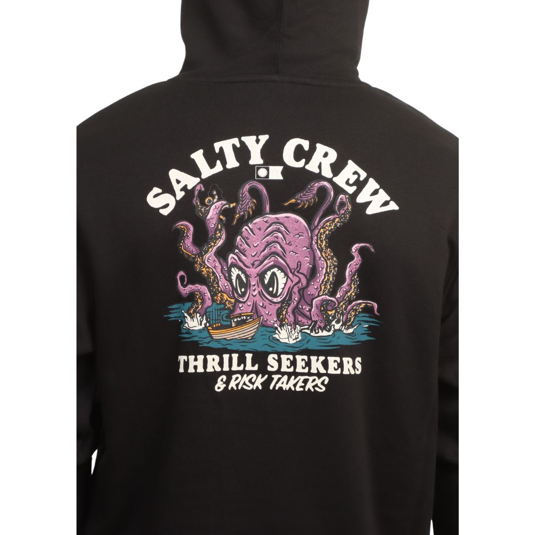 Modelo con la capucha puesta de la sudadera Salty Crew Kraken Monster en negro, mostrando el gráfico del kraken en la parte alta de la espalda junto al cordón de la capucha.