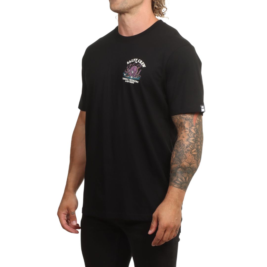 Modelo visto de perfil con la camiseta Salty Crew Kraken Monster en negro, con el gráfico del kraken y el logo Salty Crew centrados en el pecho y la etiqueta en la manga.