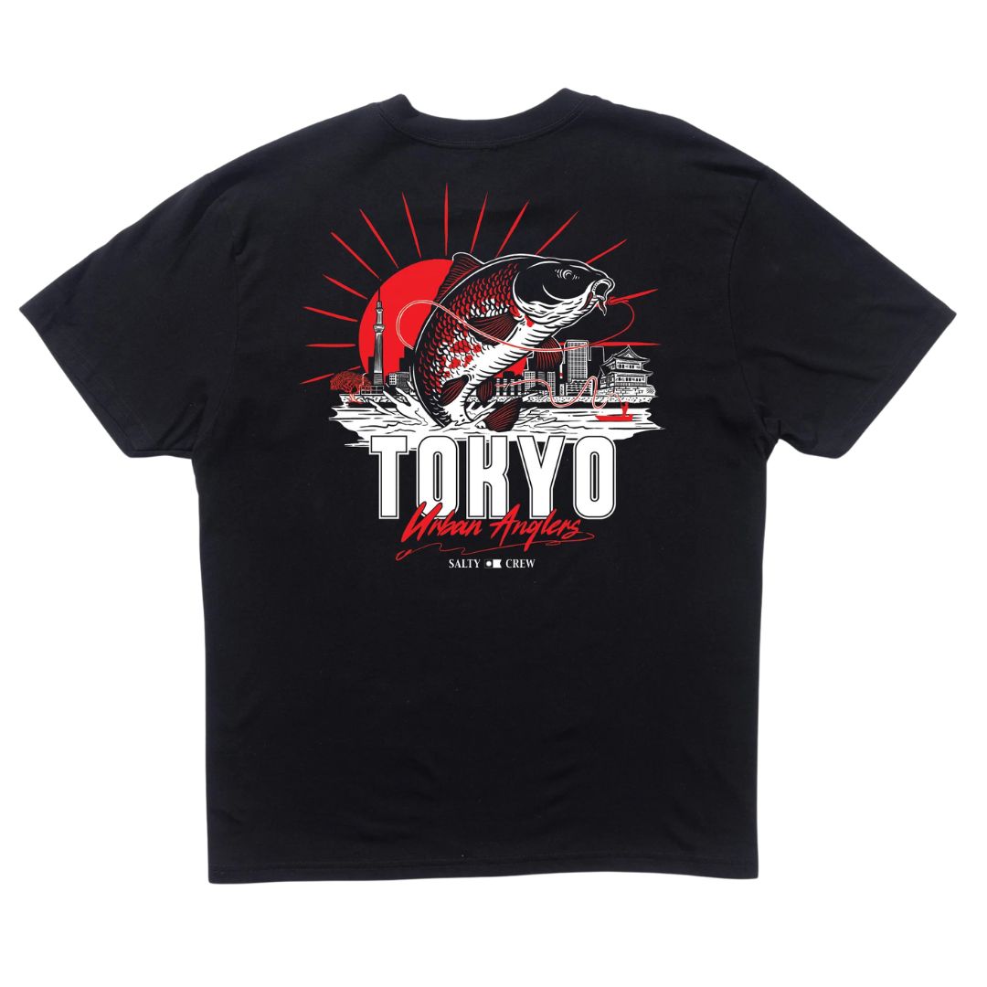 Camiseta Salty Crew Tokyo Urban Angler en color negro con diseño gráfico en la espalda de un pez koi saltando sobre el skyline de Tokio, sol naciente rojo y tipografía de estilo japonés.