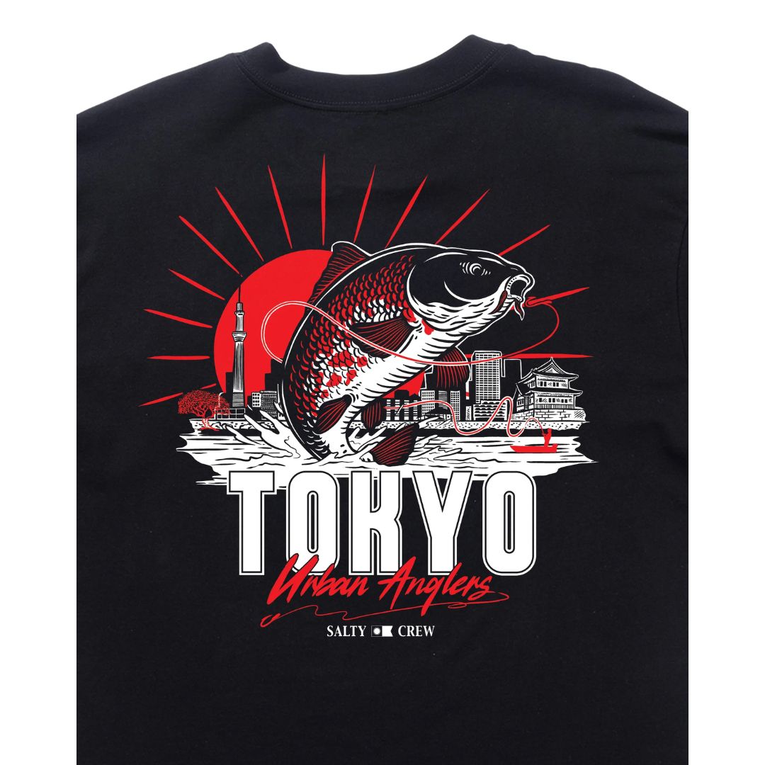 Camiseta negra Salty Crew Tokyo Urban Angler de manga corta; detalle del estampado posterior con ilustración de pesca urbana, torre Tokyo Skytree y sol rojo.