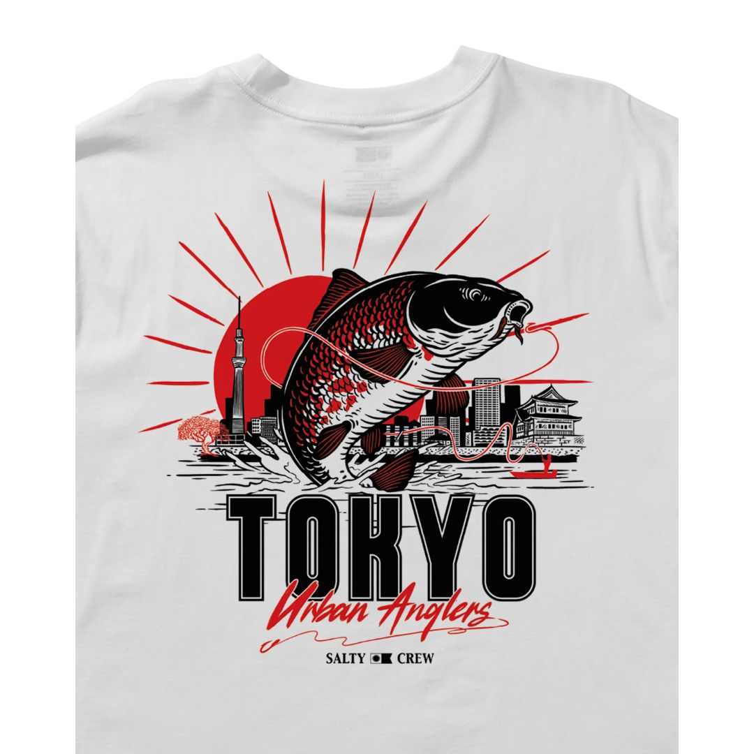 Camiseta blanca Salty Crew Tokyo Urban Angler de manga corta; detalle del estampado posterior con ilustración de pesca urbana, torre Tokyo Skytree y sol rojo.