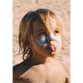 Niño en playa con protector solar blanco en cara usando stick SPF50+ Seventy One Percent para piel sensible.
