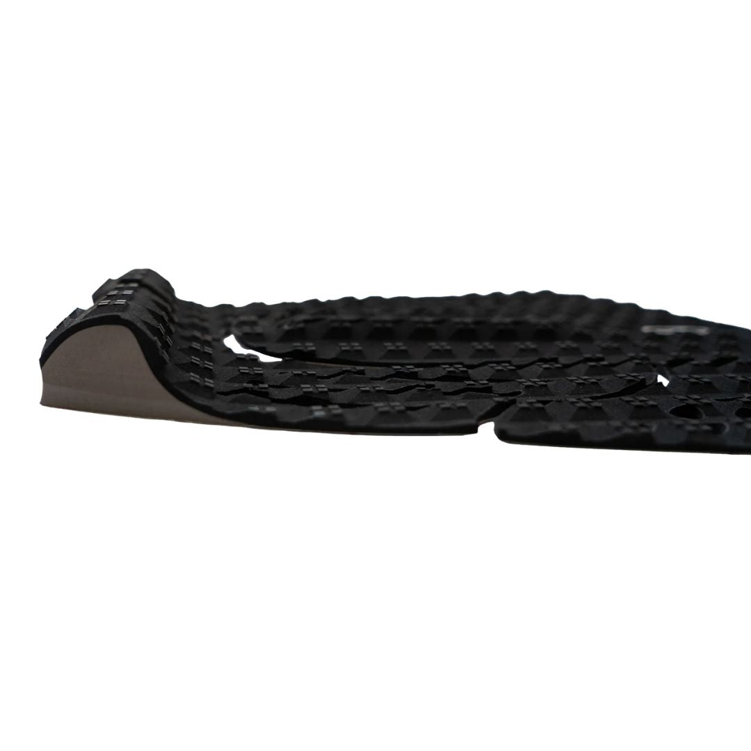 Vista lateral del grip Slater Designs 5 Piece Action Pad negro y gris, perfil bajo del kick tail gris con corte en V anti-enganche de invento y textura de diamante BLOOM de espuma de algas visible.