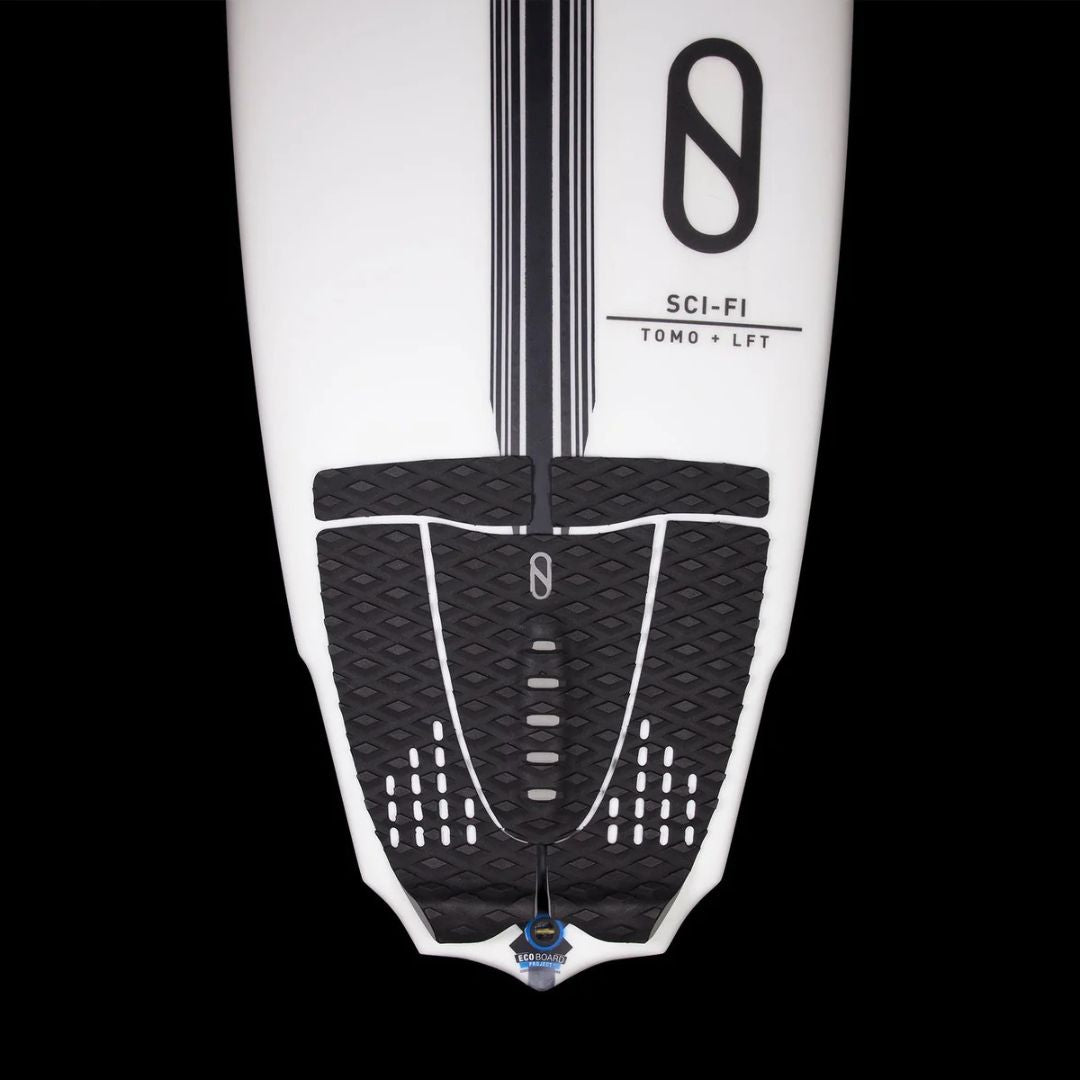 Vista cenital del grip trasero Slater Designs 5 piezas negro instalado en tabla Slater Designs Sci-Fi Tomo LFT blanca, mostrando cobertura completa de cola con textura de diamante y arco central.