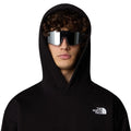 Hombre con la Sudadera con capucha AXYS Hoodie TNF Black de The North Face Negra, capucha puesta y gafas de sol