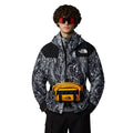 Riñonera The North Face Base Camp Lumbar Summit Gold TNF Black en uso sobre chaqueta con estampado gráfico