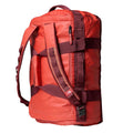 Vista lateral de la bolsa The North Face Base Camp Voyager Duffel 42L color Mars Dust con asas y tirantes tipo mochila.