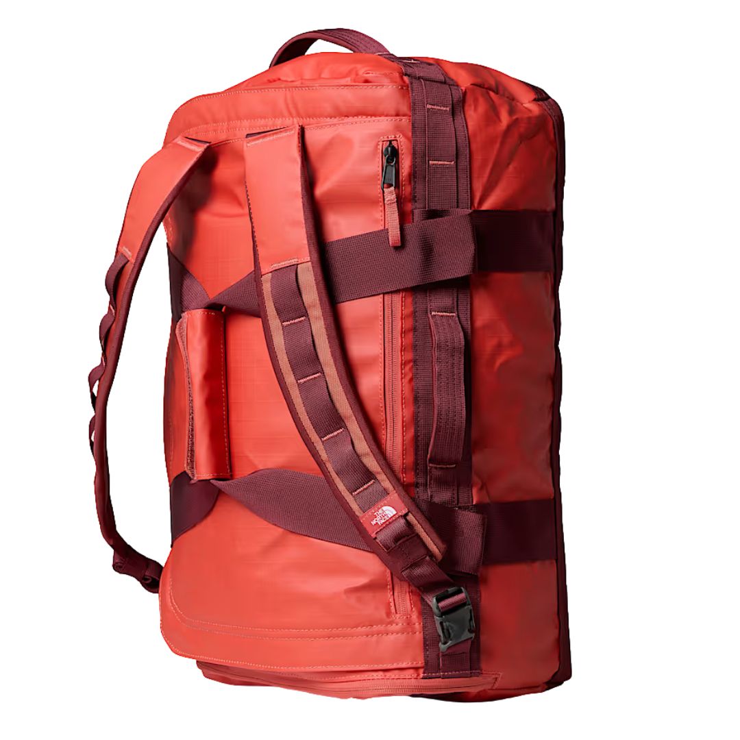 Vista lateral de la bolsa The North Face Base Camp Voyager Duffel 42L color Mars Dust con asas y tirantes tipo mochila.
