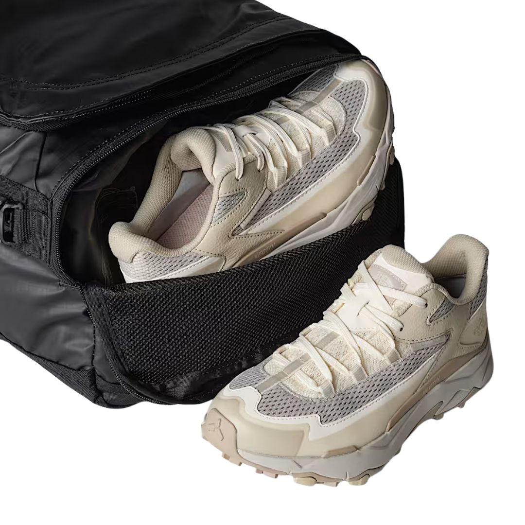 Bolsa The North Face Base Camp Voyager Duffel 42L en color TNF Black/Asphalt Grey con compartimento lateral abierto mostrando zapatillas deportivas.