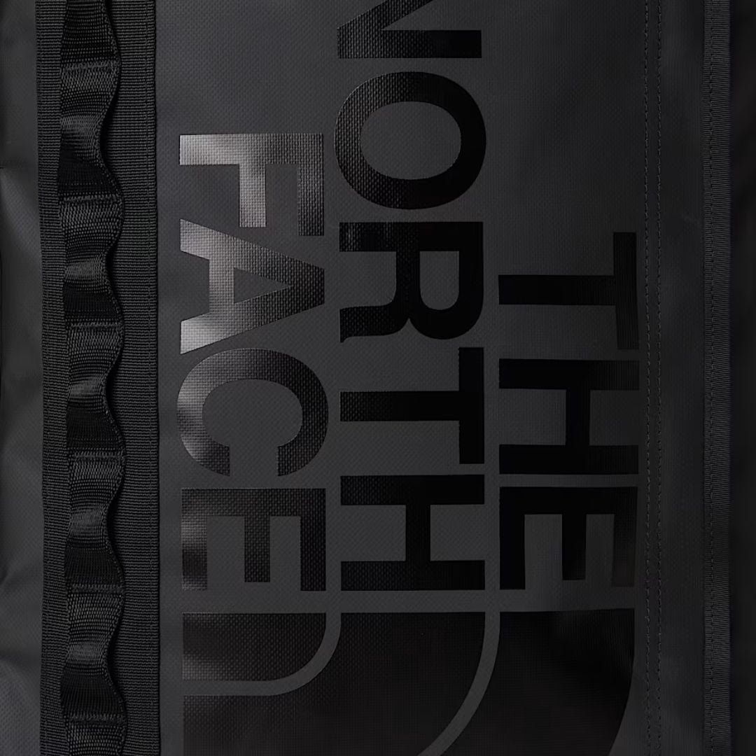Detalle del logotipo The North Face serigrafiado en negro sobre negro en la mochila Base Camp Fuse Box.