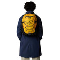 Mochila The North Face Borealis Classic en color Summit Gold colocada sobre la espalda del modelo