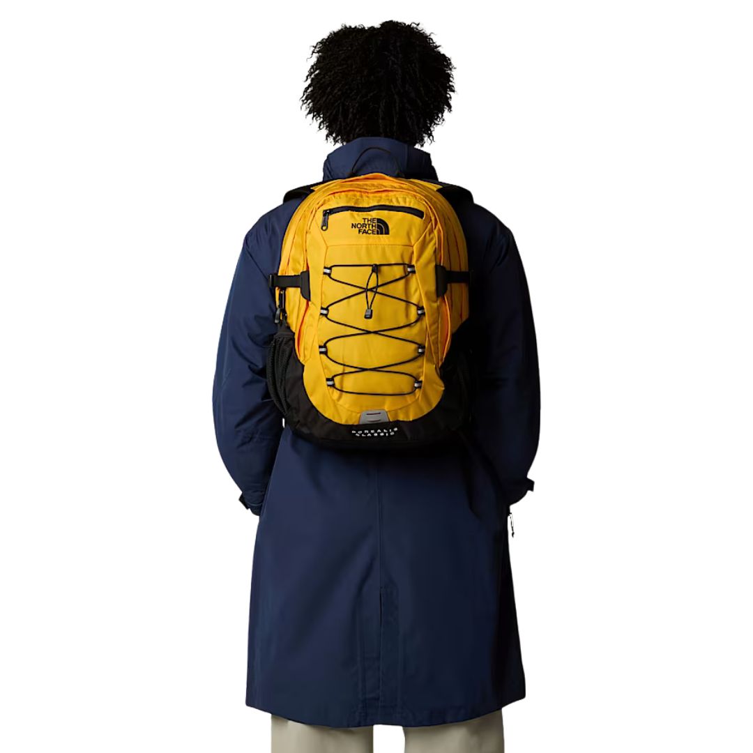 Mochila The North Face Borealis Classic en color Summit Gold colocada sobre la espalda del modelo