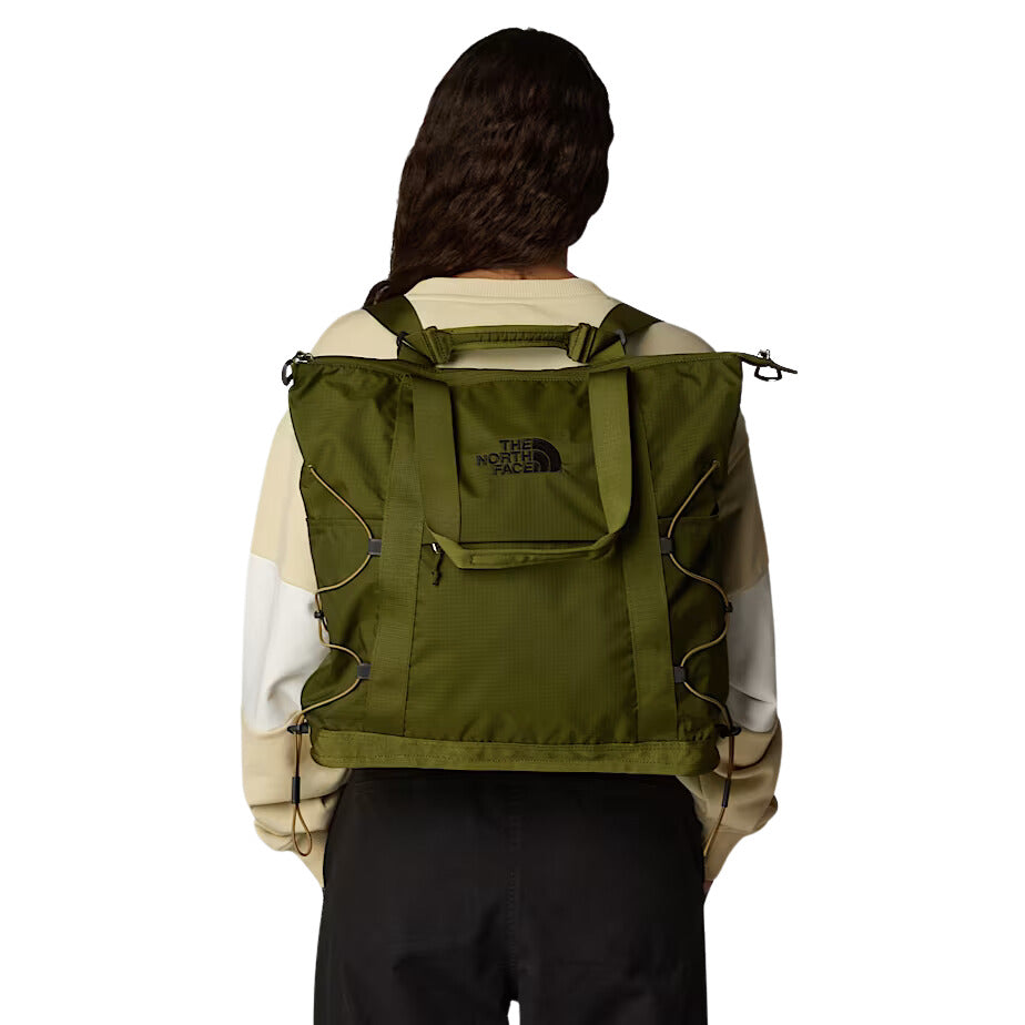 Modelo llevando el bolso The North Face Borealis Tote en color Forest Olive como mochila.