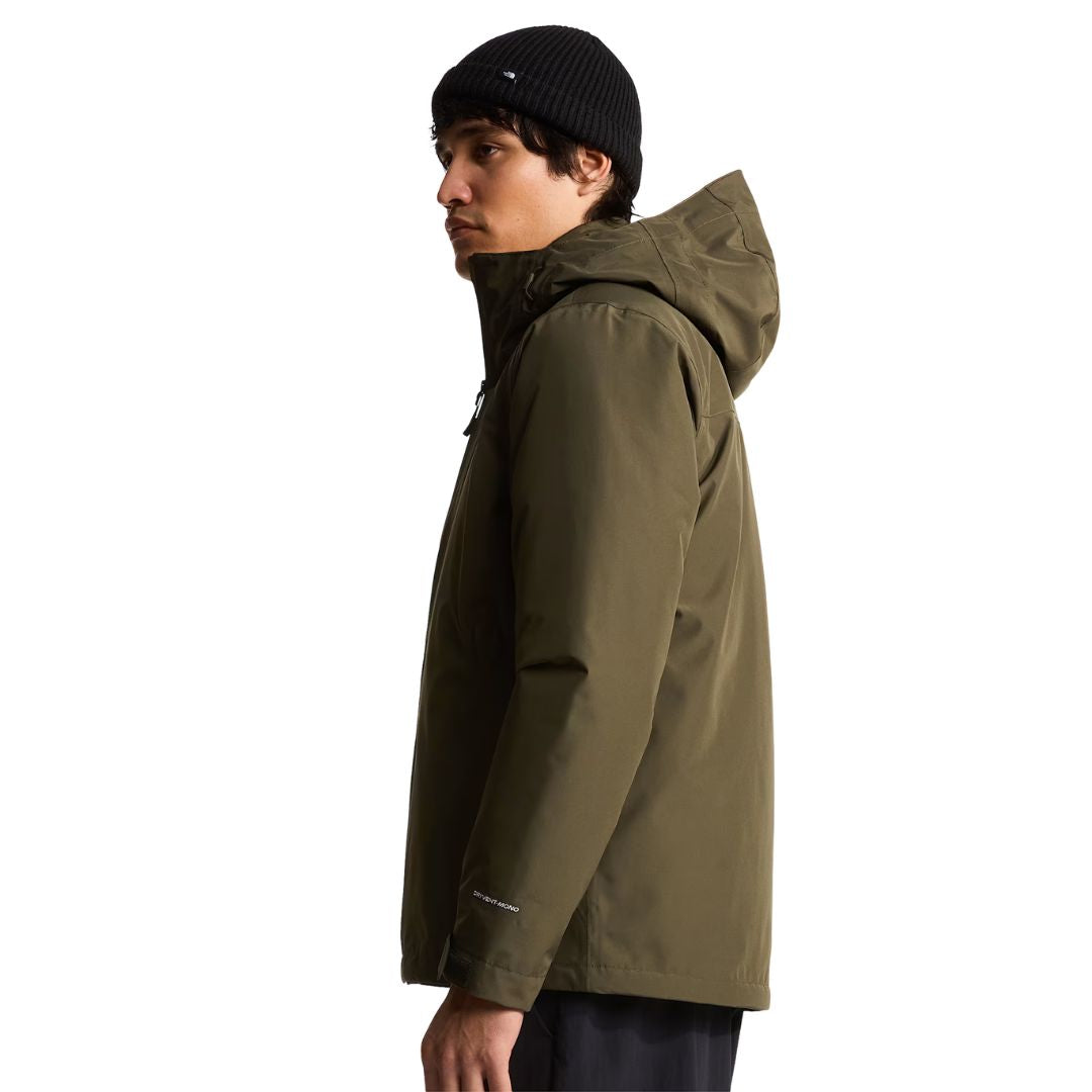 Vista lateral del modelo con la chaqueta The North Face Carto Mono Triclimate en New Taupe Green, mostrando la silueta del corte estándar y los puños ajustables.