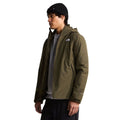 Vista de tres cuartos del modelo con la chaqueta The North Face Carto Mono Triclimate en New Taupe Green, mostrando el ajuste de la capucha integrada.
