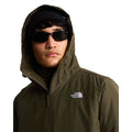 Retrato de modelo con la capucha puesta de la chaqueta The North Face Carto Mono Triclimate en New Taupe Green, con logotipo bordado visible en el pecho izquierdo.
