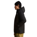 Perfil lateral de la chaqueta The North Face Carto Mono Triclimate negra con capucha de visera estructurada, bolsillo de mano con cremallera y puño ajustable en la manga.