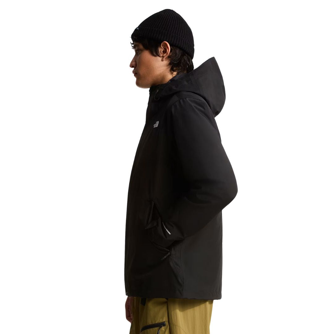 Perfil lateral de la chaqueta The North Face Carto Mono Triclimate negra con capucha de visera estructurada, bolsillo de mano con cremallera y puño ajustable en la manga.