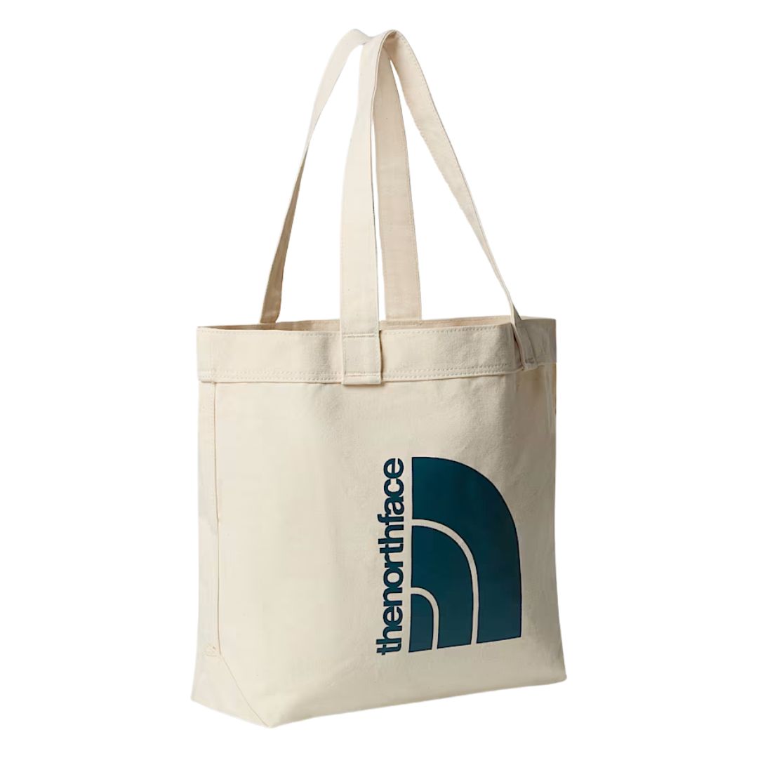 Bolso tote The North Face Cotton Tote en color natural con gran logo azul, imagen de producto sobre fondo neutro"