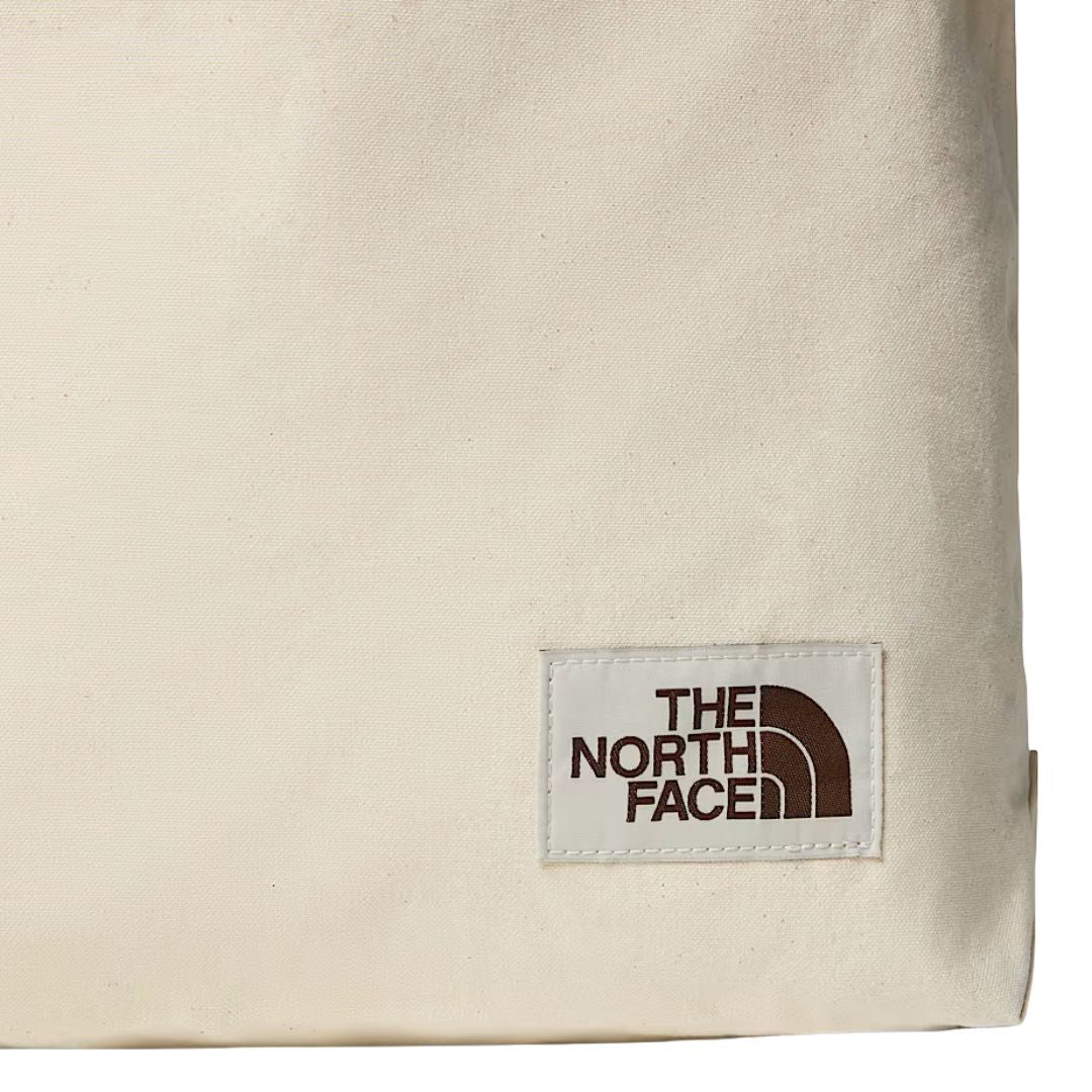 Detalle del logo The North Face bordado en etiqueta en bolso Cotton Tote, color natural con detalles marrones