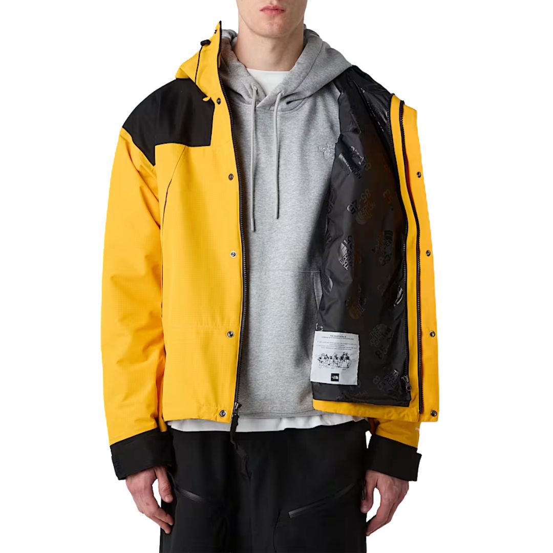 Chaqueta The North Face Dryvent Mono Mountain Summit Gold y negro TNF abierta, mostrando interior con forro.