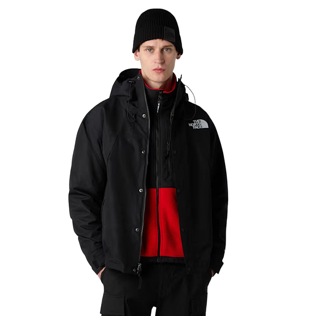 Modelo vistiendo la chaqueta The North Face Dryvent Mono Mountain Jacket en color TNF Black con forro rojo.