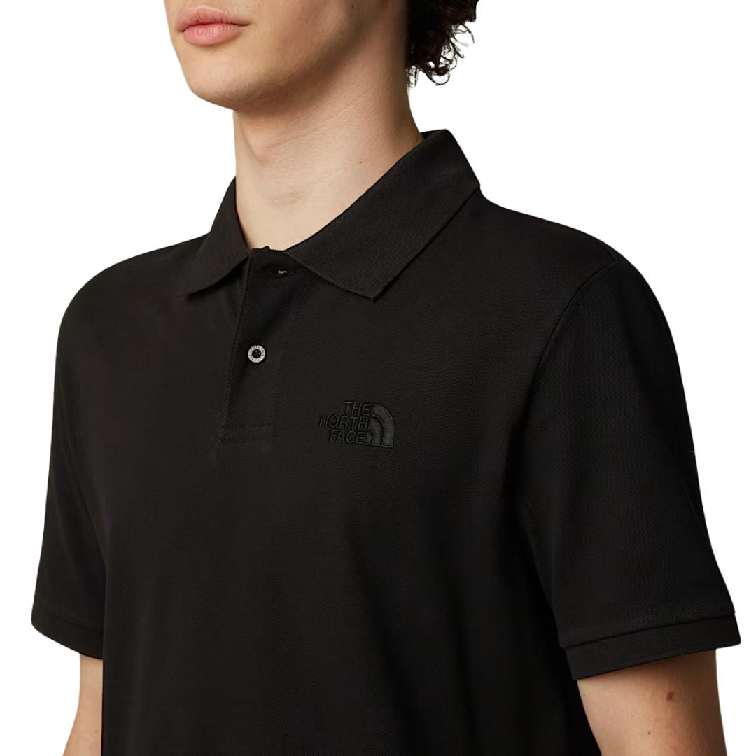 Polo negro The North Face Essential Polo Tee con logo bordado al pecho.