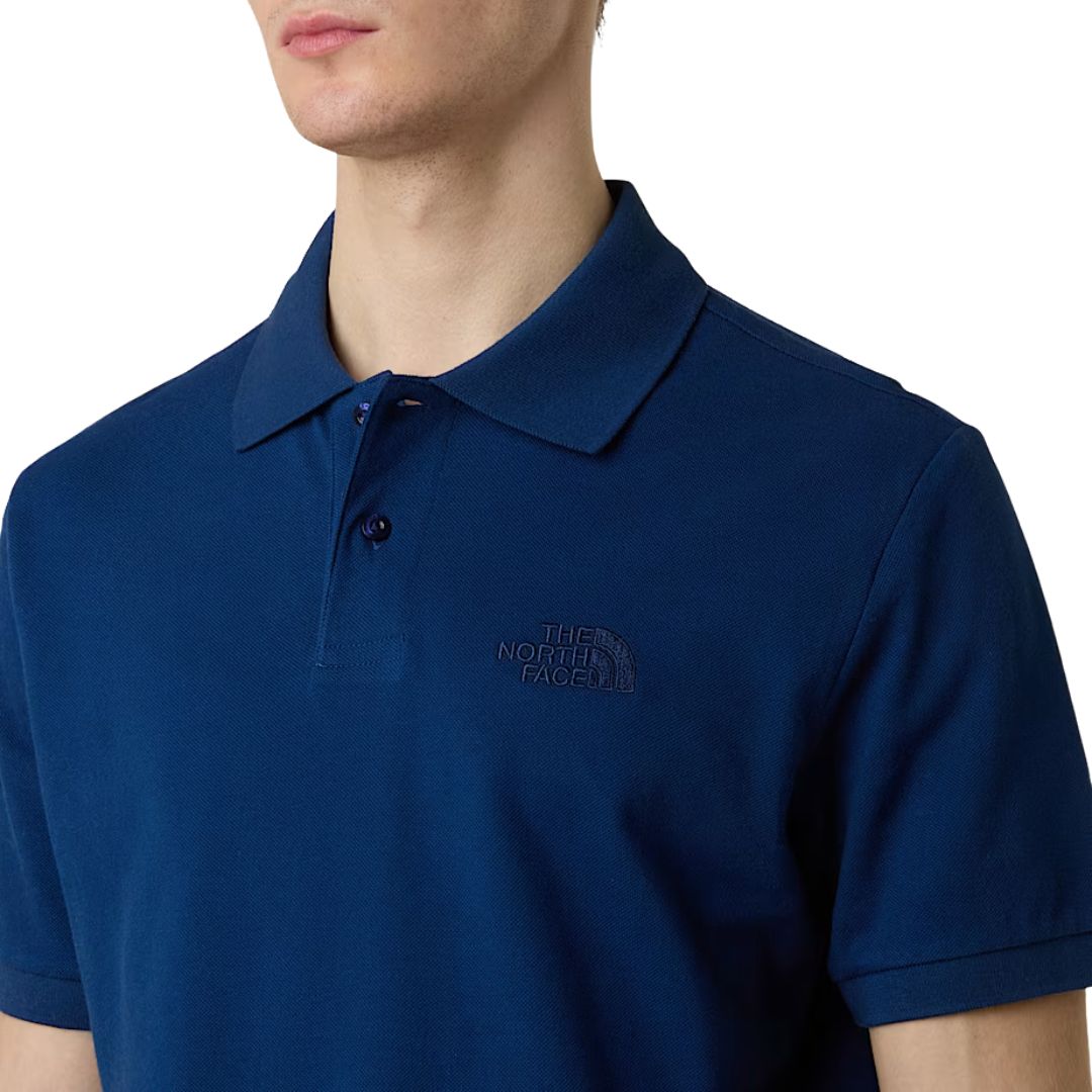 Polo The North Face Essential Regular azul Estate Blue, detalle del cuello tipo polo y logo bordado.